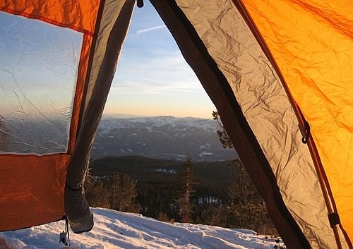 A view looking out from the inside of a tent over a vast landscape.